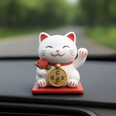 Lucky Cat Figurine – Waving Fortune Cat in Display Box on a dashboard, symbolizing good luck and prosperity.